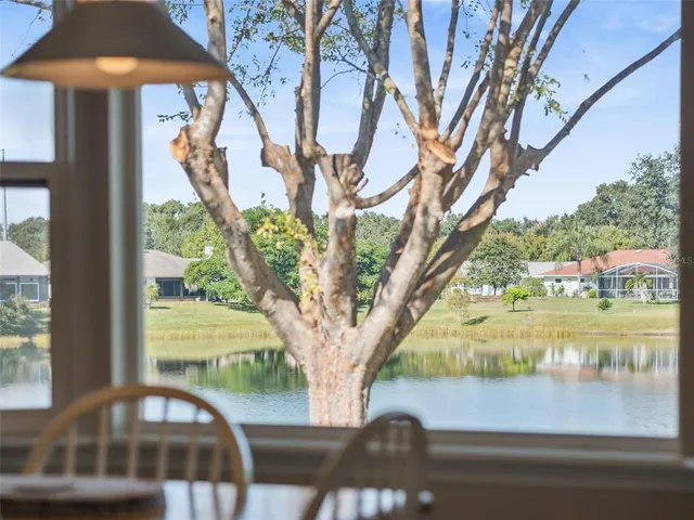 a kitchen with stainless steel appliances granite countertop a refrigerator a stove a sink a microwave a dining table and chairs with wooden floor