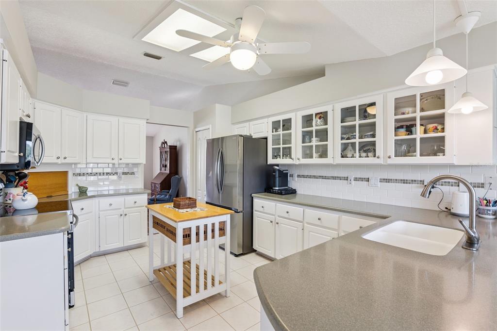 26450 Evert Street Leesburg, FL 34748 - Photo 15 of 93 a kitchen with stainless steel appliances granite countertop a stove refrigerator a sink dishwasher with a dining table and chairs