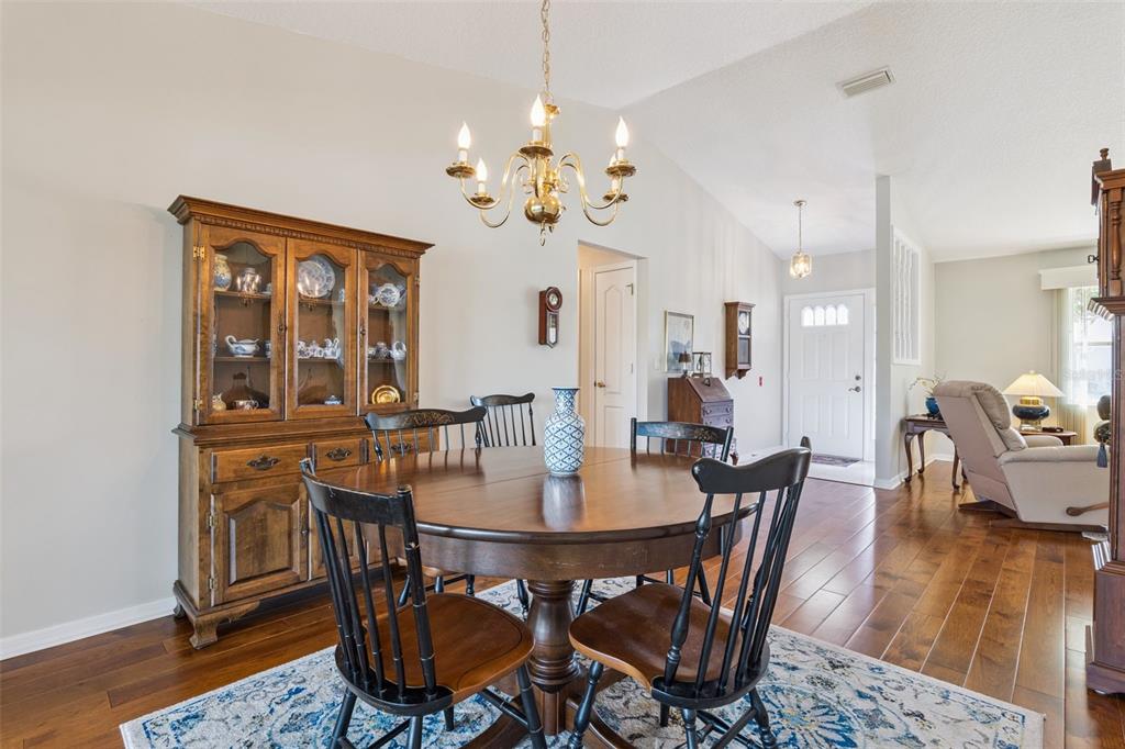 26450 Evert Street Leesburg, FL 34748 - Photo 21 of 93 a view of a dining room with furniture a chandelier and wooden floor