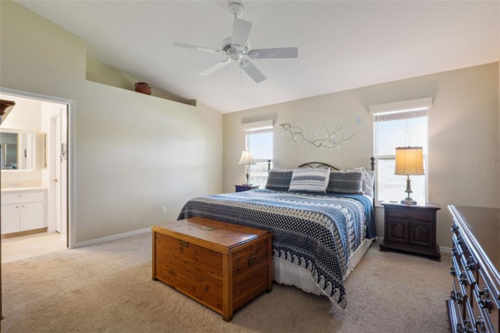 26450 Evert Street Leesburg, FL 34748 - Photo 25 of 93 a spacious bedroom with a bed and a chandelier