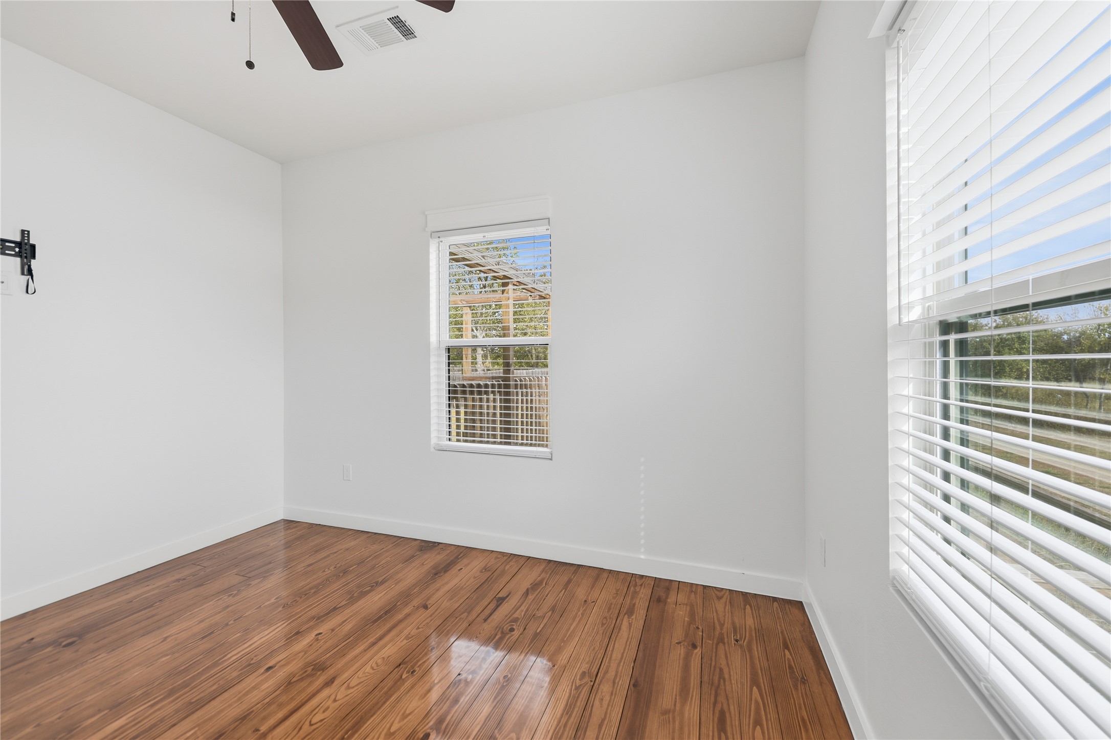 704 Burleson Street Brenham, TX 77833 - Photo 17 of 28 an empty room with wooden floor and windows
