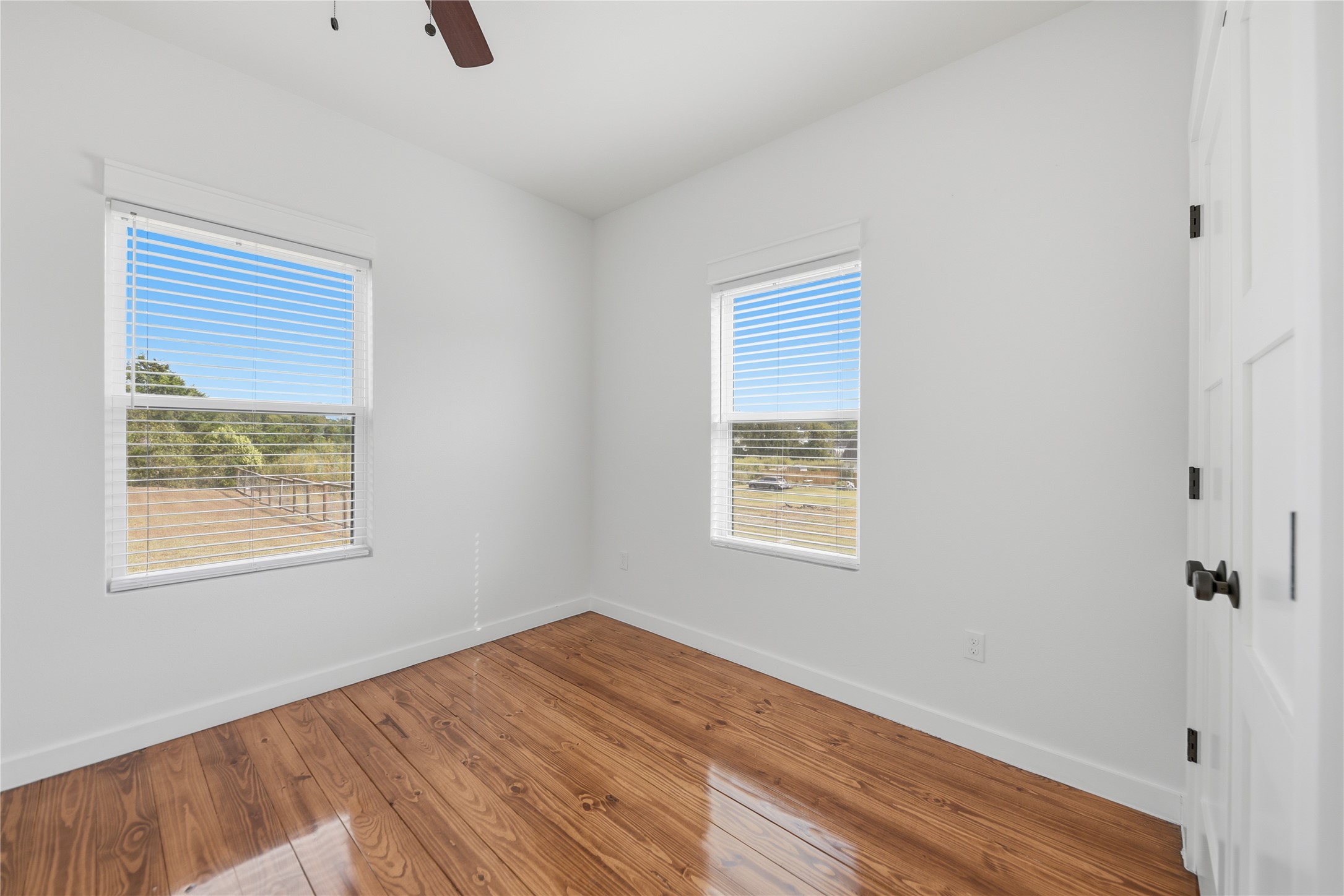 704 Burleson Street Brenham, TX 77833 - Photo 19 of 28 a view of an empty room with wooden floor and a window