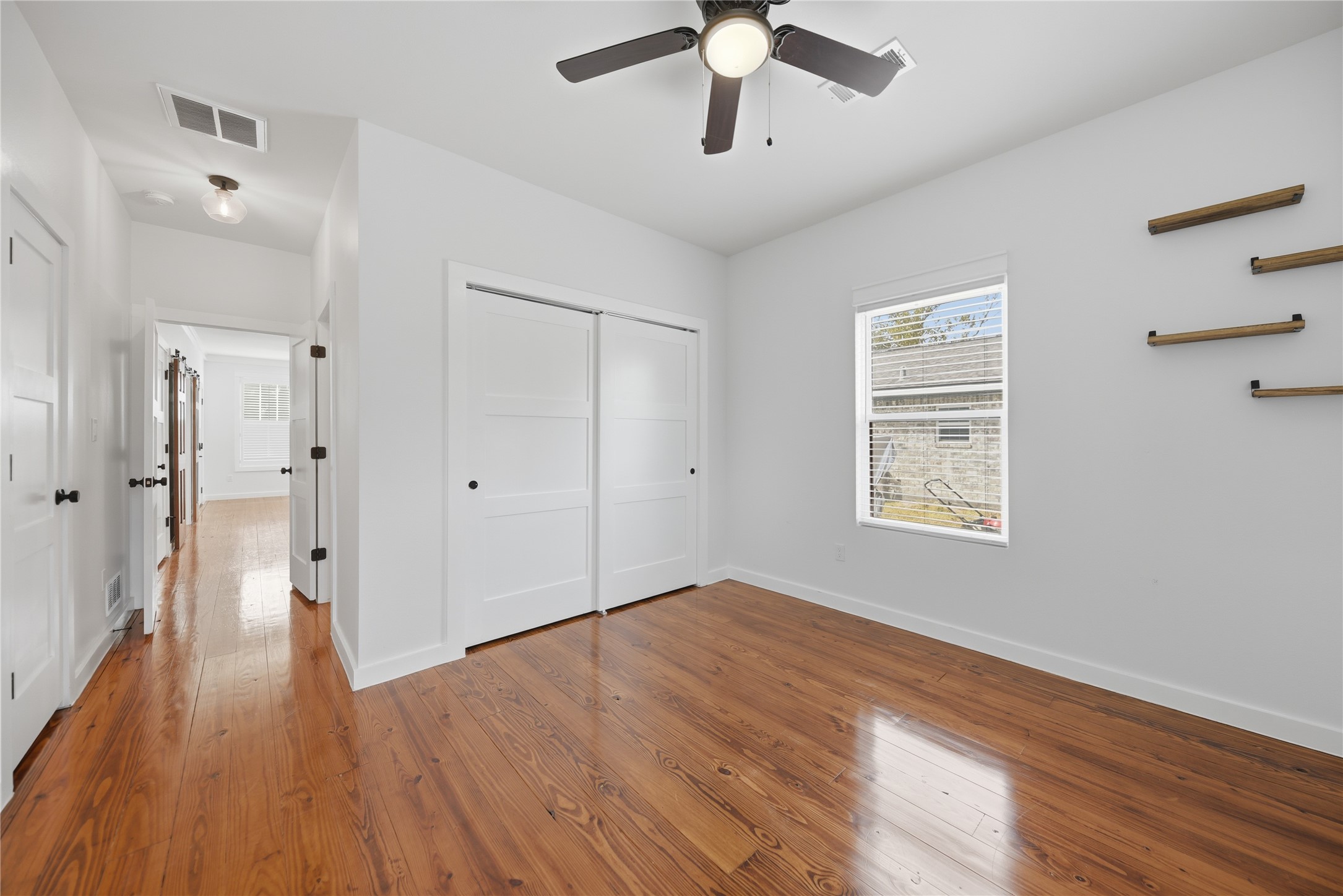 704 Burleson Street Brenham, TX 77833 - Photo 21 of 28 wooden floor in an empty room with a window