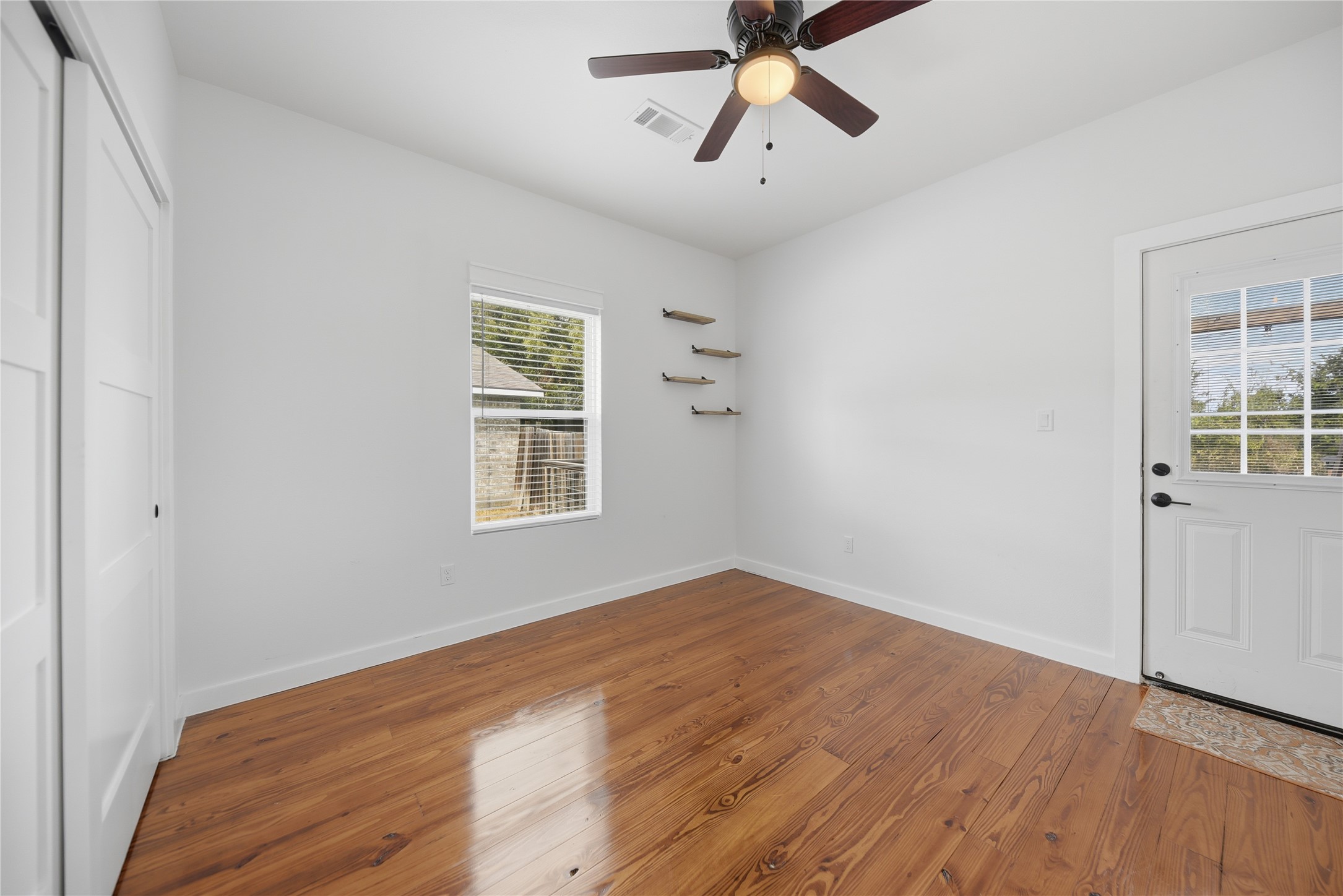 704 Burleson Street Brenham, TX 77833 - Photo 22 of 28 a view of a room with wooden floor and windows