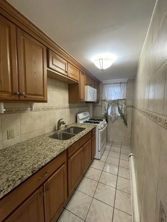 4 Conduit Street, Unit 1 Lawrence, MA 01841 - Photo 3 of 14 a kitchen with stainless steel appliances granite countertop a sink stove and refrigerator