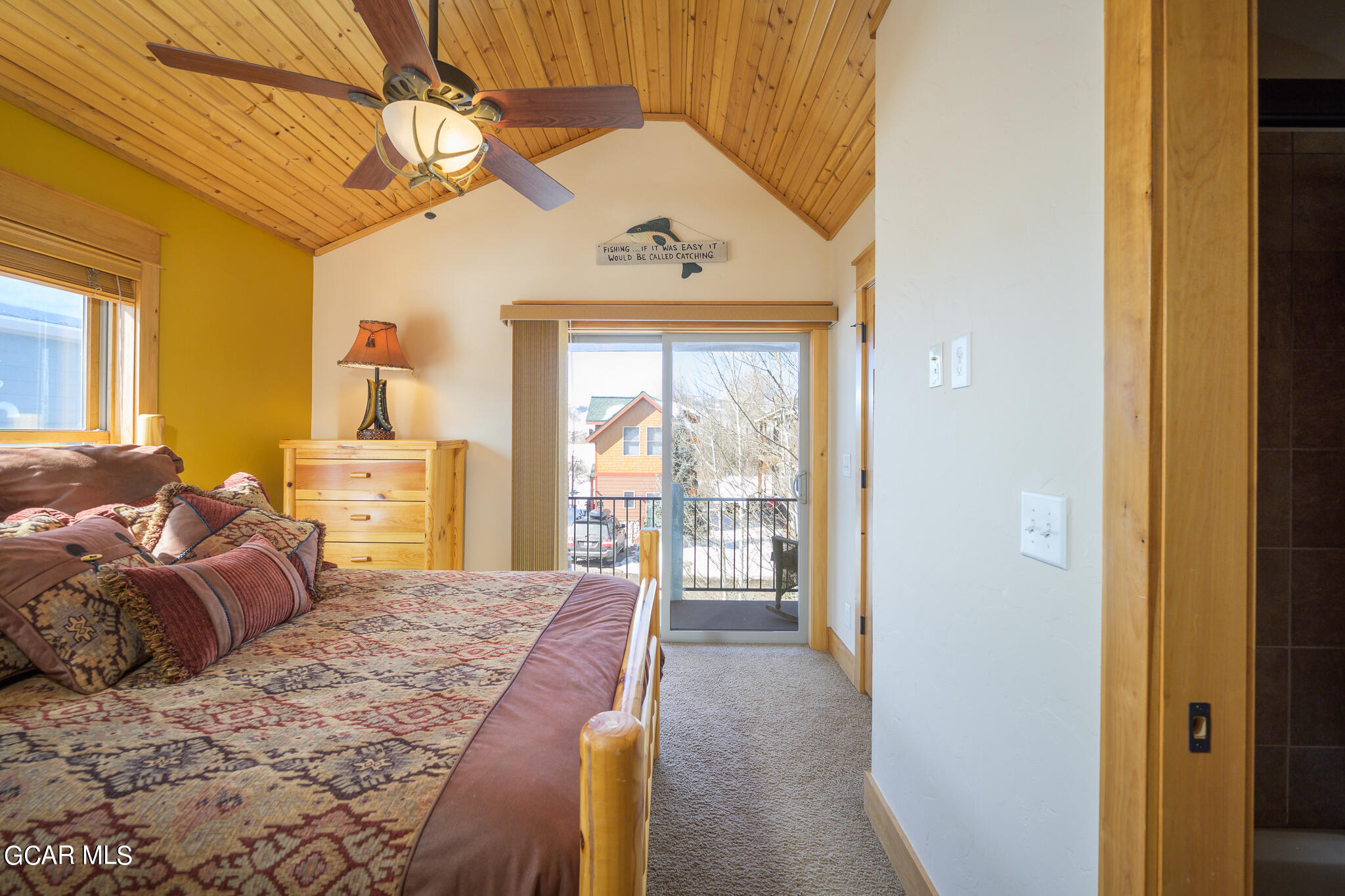 129 Edgewater Circle Granby, CO 80446 - Photo 19 of 63 a bedroom with a large bed and a chandelier
