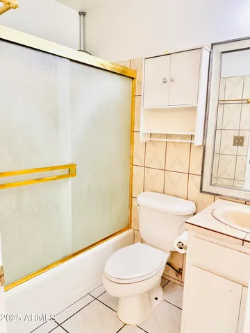 a white toilet sitting next to a bathroom next to a sink