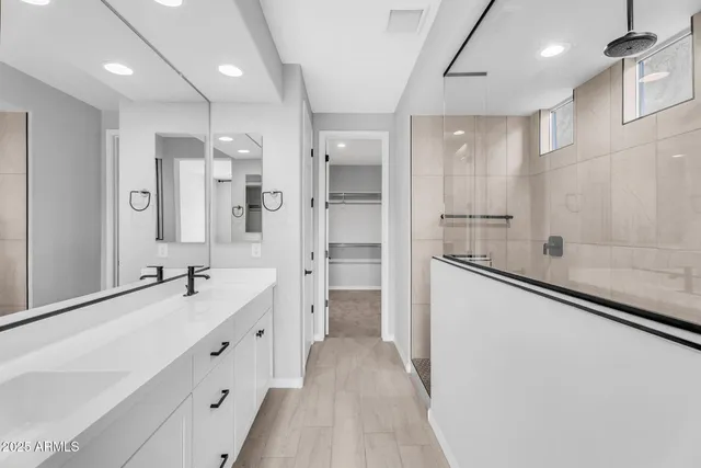 a bathroom with a double vanity sink a mirror and a shower