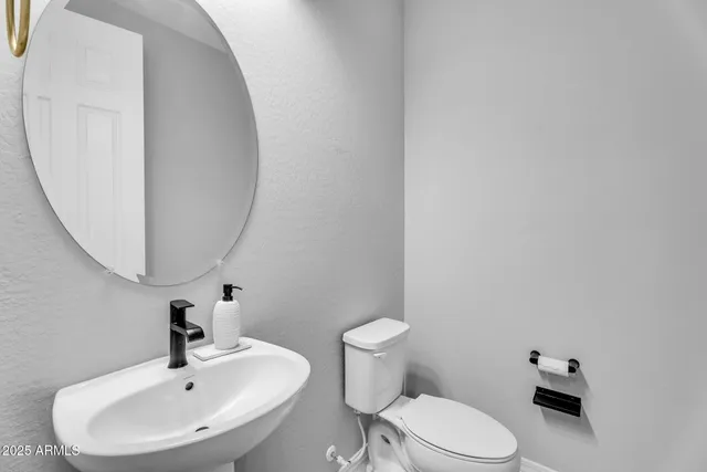a bathroom with a sink a mirror and a toilet