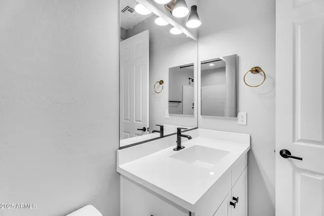 a bathroom with a sink a mirror and vanity