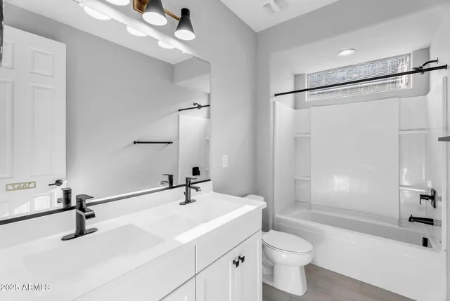 a bathroom with a sink toilet a mirror and shower