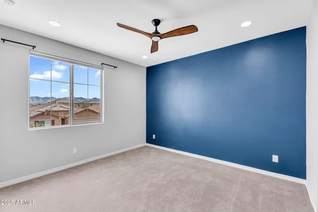 an empty room with windows and ceiling fan