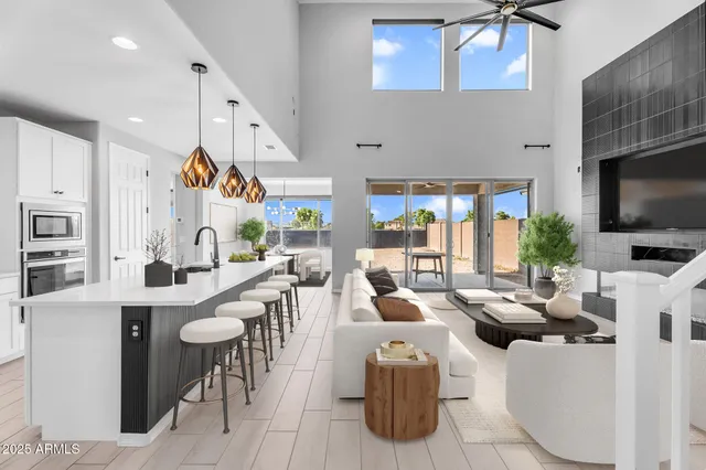 a very nice looking living room with stainless steel appliances furniture a fireplace and a flat screen tv