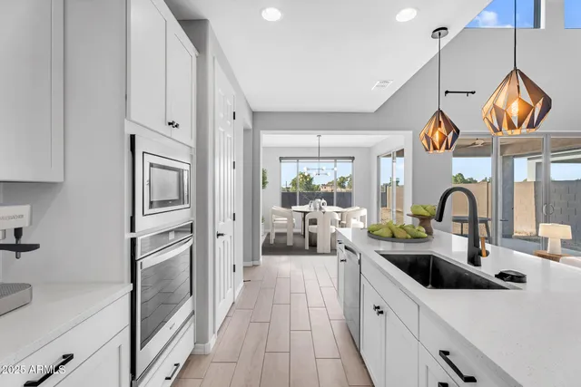 a kitchen with stainless steel appliances granite countertop a sink and a refrigerator