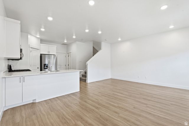 1173 West 1870 South Logan, UT 84321 - Photo 5 of 33 Open-concept living space featuring wood-finish flooring, recessed lighting, and a white kitchen with stainless steel appliances