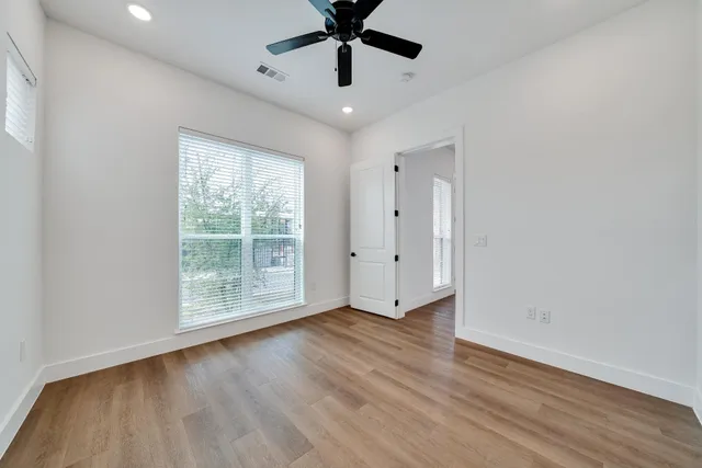a view of room with window ceiling fan and hardwood floor
