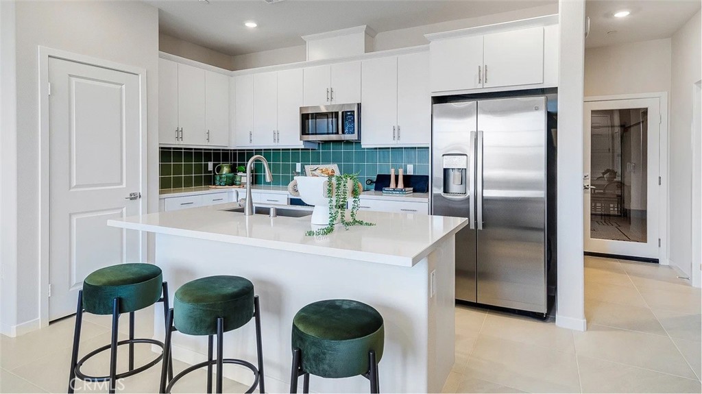2577 Cloudview Privado Ontario, CA 91761 - Photo 2 of 19 a kitchen with stainless steel appliances a refrigerator a stove a sink and white cabinets