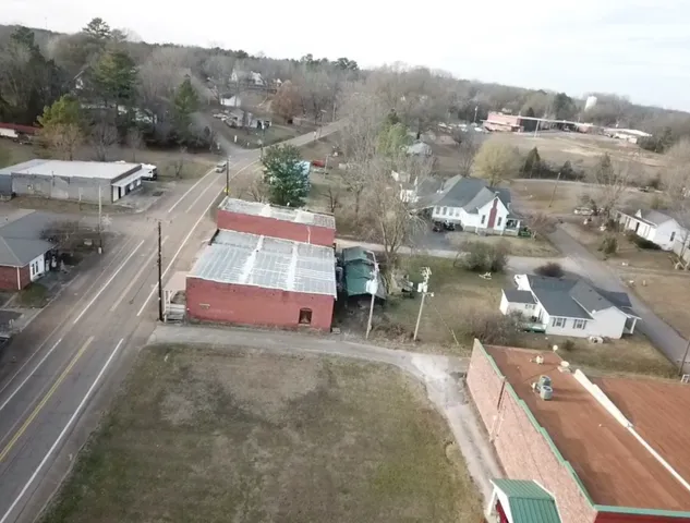 a front view of a building with a garden and plants