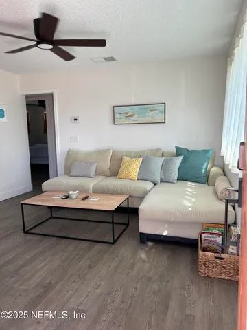 a living room with furniture and a ceiling fan