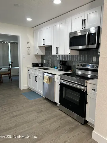 a kitchen with stainless steel appliances granite countertop a stove top oven microwave and cabinets