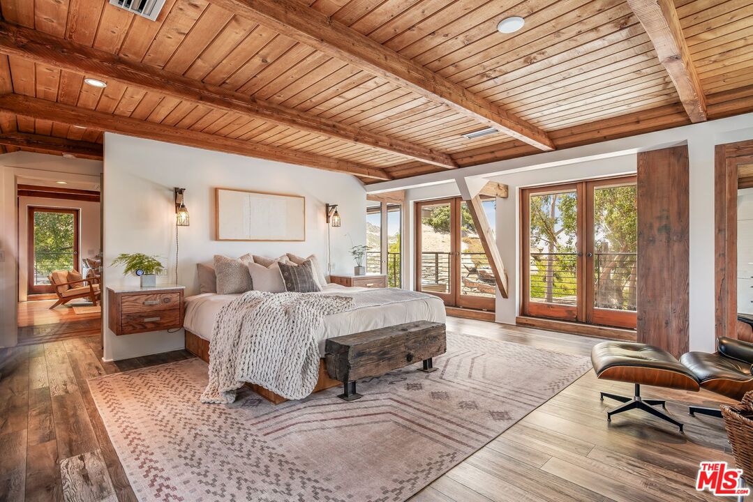 7336 Studio Road West Hills, CA 91304 - Photo 17 of 56 a spacious bedroom with a large bed and a wooden floor