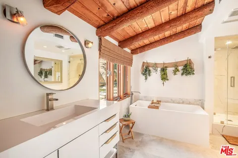 a bedroom with a large bed couch and a large window with outer view