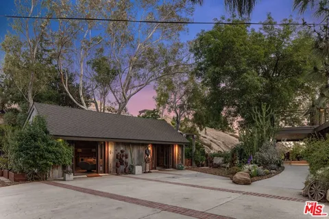 a backyard of a house with table and chairs