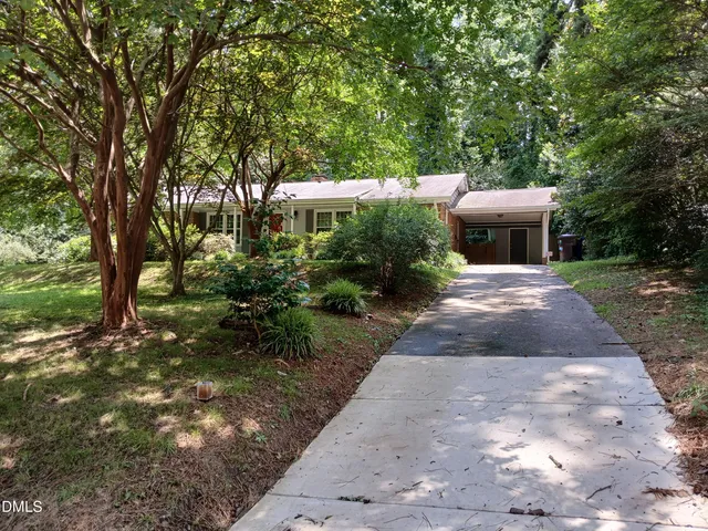 a front view of a house with a yard and potted plants