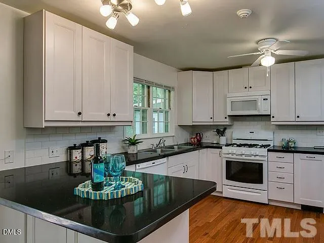 a kitchen with stainless steel appliances granite countertop a stove a sink dishwasher and cabinets with wooden floor