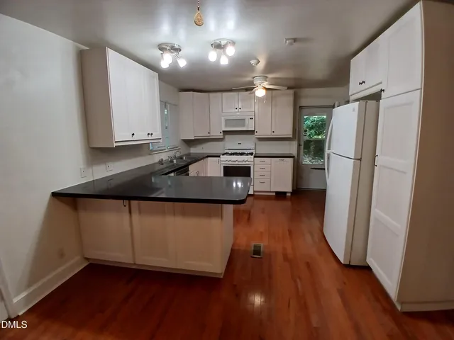a kitchen with kitchen island a counter top space a sink a refrigerator and a stove