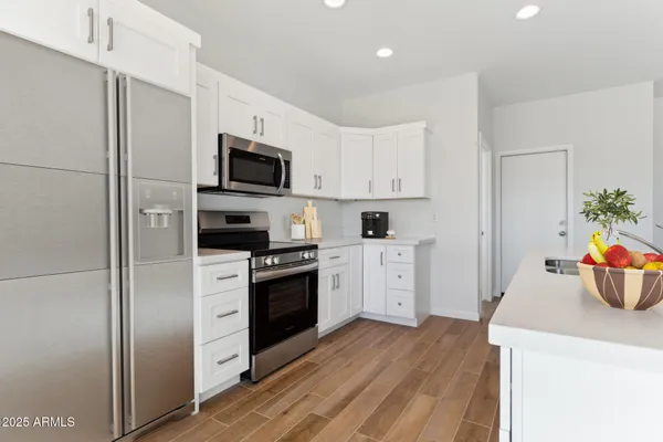 a kitchen with stainless steel appliances a stove microwave and a refrigerator