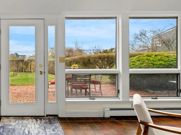a bedroom with a bed and a large window with wooden floor