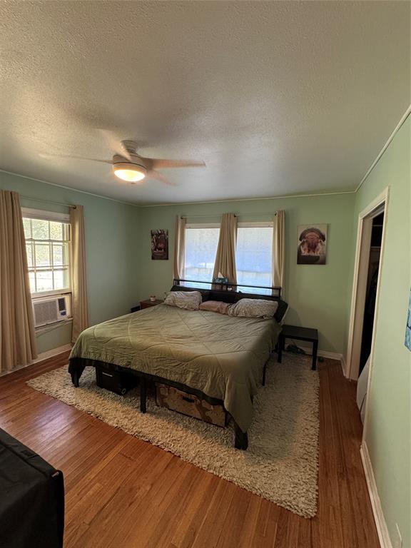 724 South Rusk Street Gainesville, TX 76240 - Photo 14 of 29 a bedroom with a bed and wooden floor