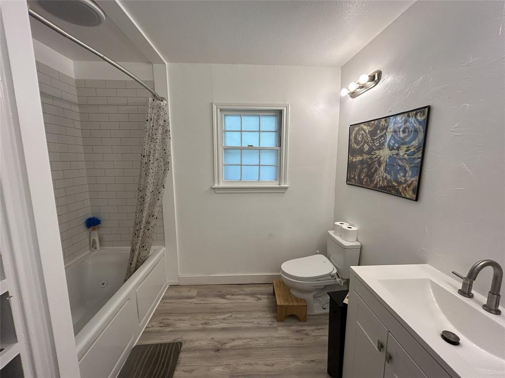724 South Rusk Street Gainesville, TX 76240 - Photo 17 of 29 a bathroom with a sink toilet and shower