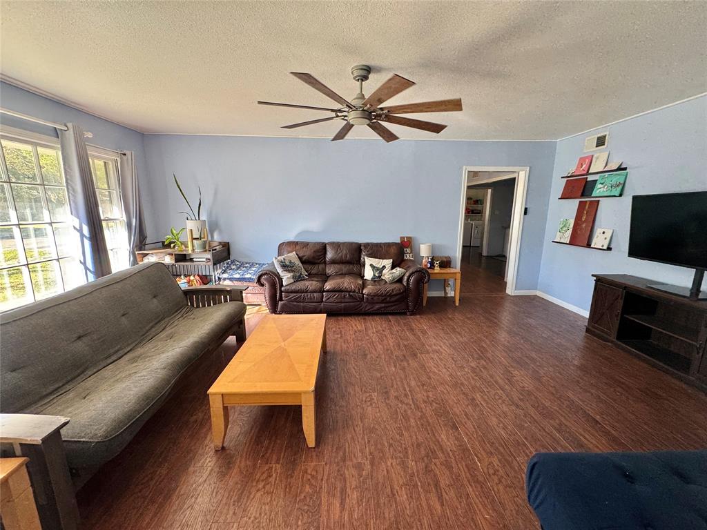 724 South Rusk Street Gainesville, TX 76240 - Photo 2 of 29 a living room with furniture and a flat screen tv