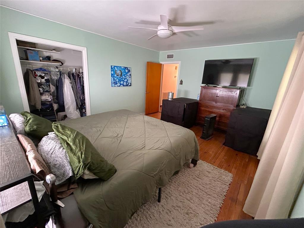 724 South Rusk Street Gainesville, TX 76240 - Photo 22 of 29 a bedroom with a bed and wooden floor
