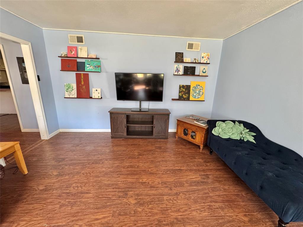 724 South Rusk Street Gainesville, TX 76240 - Photo 3 of 29 a living room with furniture and a flat screen tv