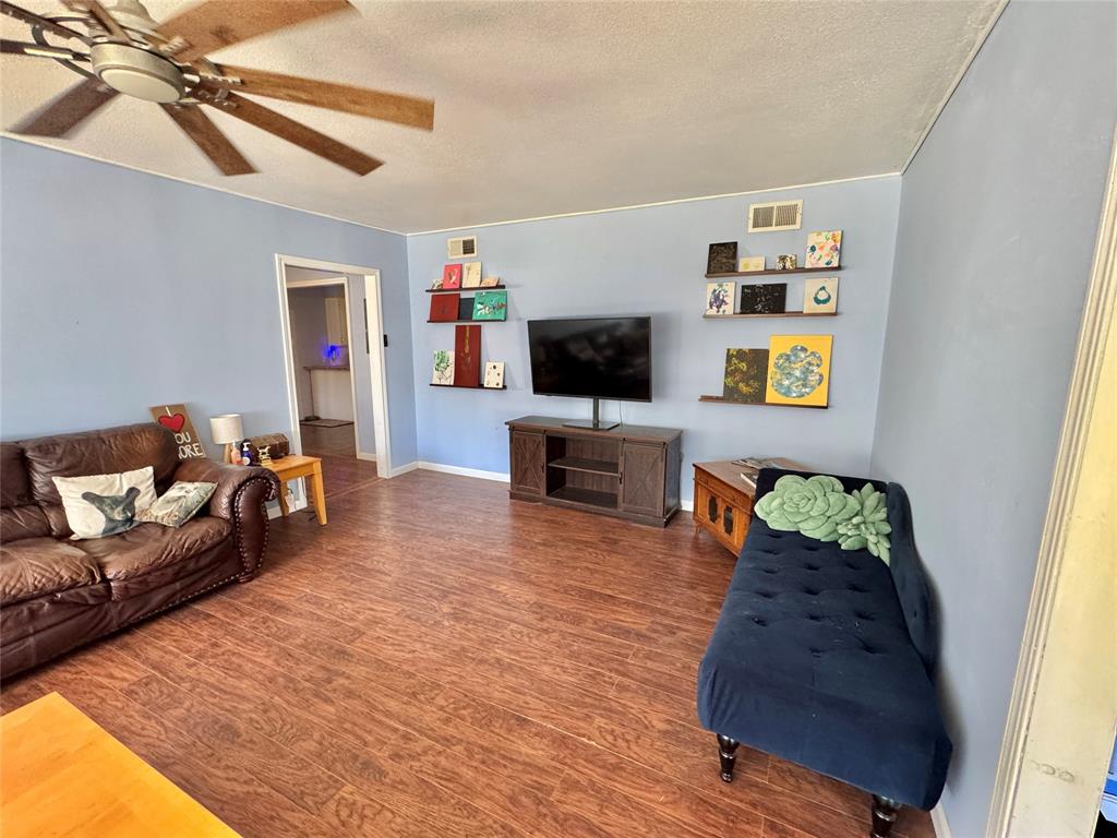 724 South Rusk Street Gainesville, TX 76240 - Photo 4 of 29 a living room with furniture and a flat screen tv