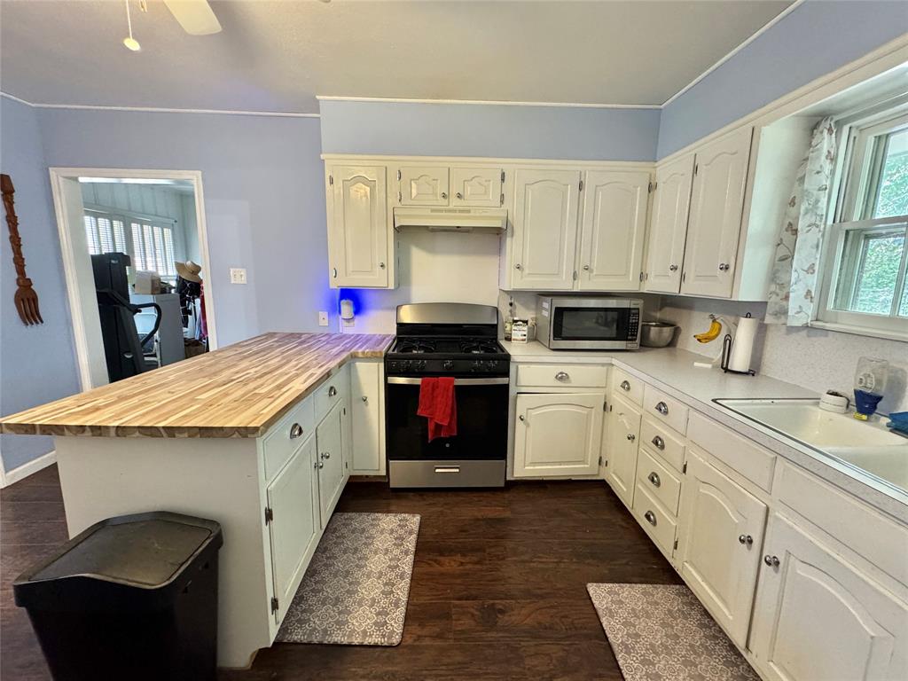 724 South Rusk Street Gainesville, TX 76240 - Photo 7 of 29 a kitchen with granite countertop white cabinets and white appliances