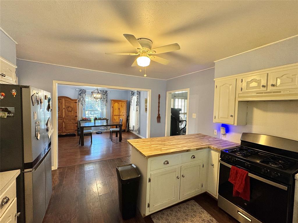 724 South Rusk Street Gainesville, TX 76240 - Photo 10 of 29 a kitchen with a stove a refrigerator and a stove