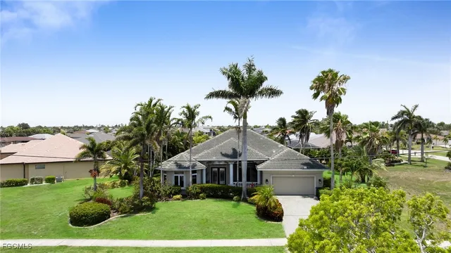 a front view of a house with a yard and potted plants