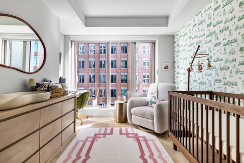 a spacious bedroom with a large bed a couch and a large window