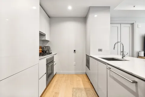 a kitchen with a sink and white cabinets