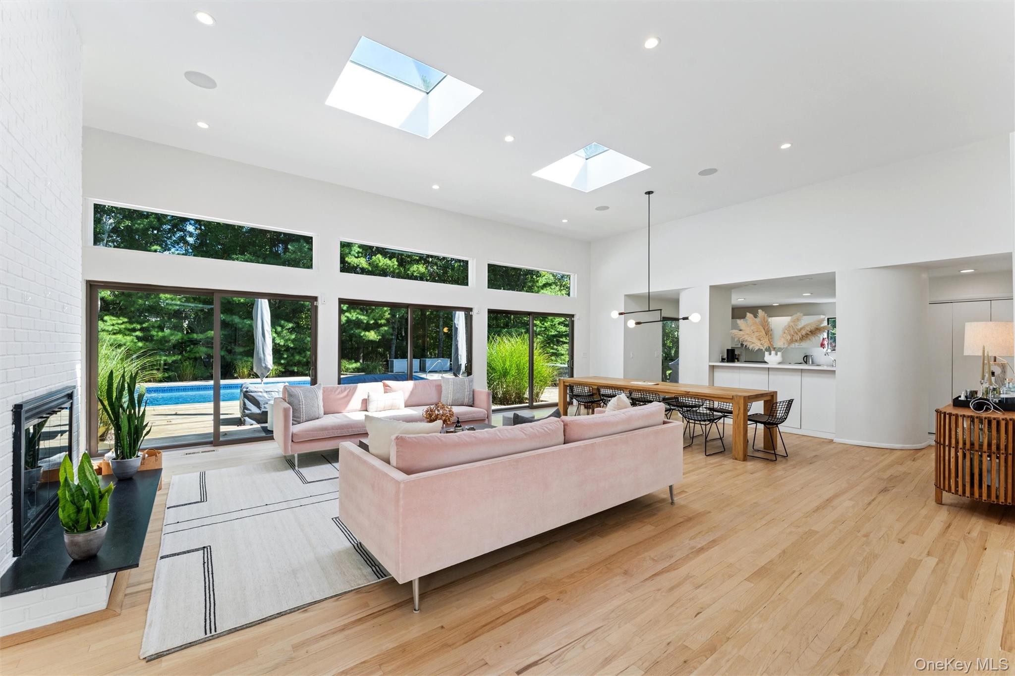 8 Deer Path Quogue, NY 11959 - Photo 3 of 23 Living room featuring recessed lighting, a towering ceiling, light wood-style flooring, plenty of natural light, and a skylight