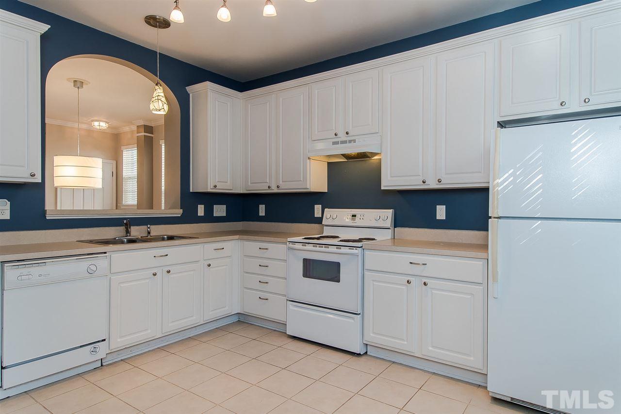8312 City Loft Court Raleigh, NC 27613 - Photo 11 of 23 a kitchen with granite countertop white cabinets and white appliances