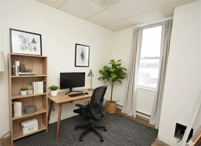 a view of a workspace with furniture and a window