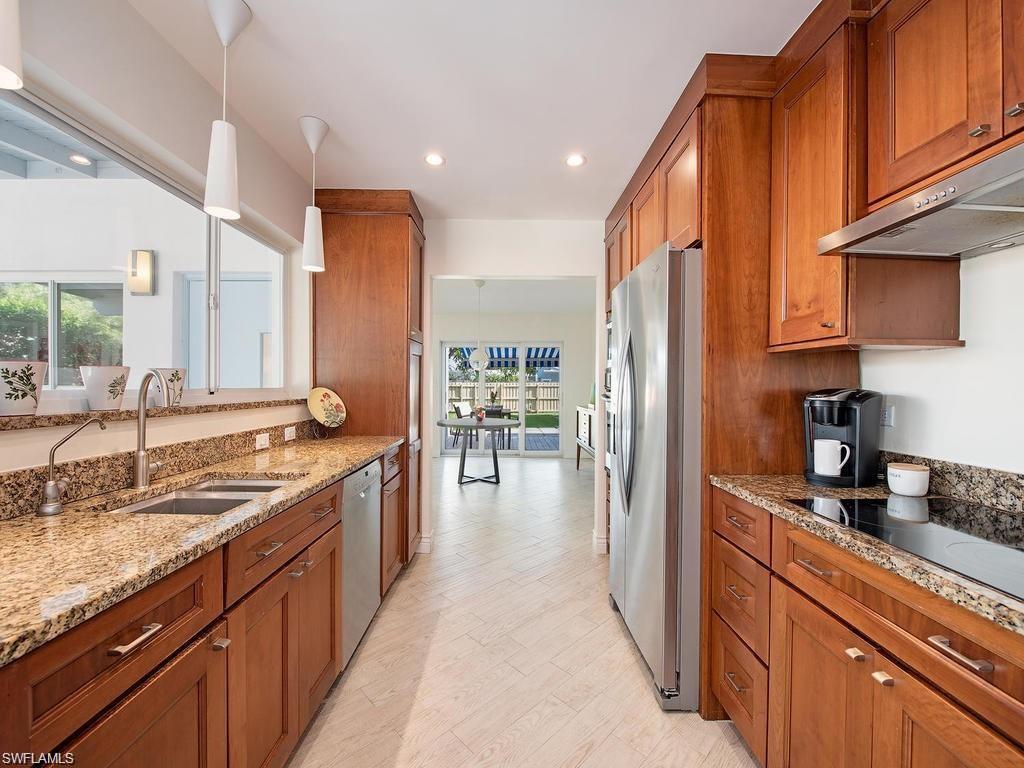 757 Broad Court South Naples, FL 34102 - Photo 4 of 12 a kitchen with stainless steel appliances granite countertop a stove a sink and a refrigerator