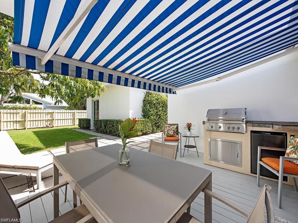 757 Broad Court South Naples, FL 34102 - Photo 10 of 12 a view of a patio with table and chairs near a yard