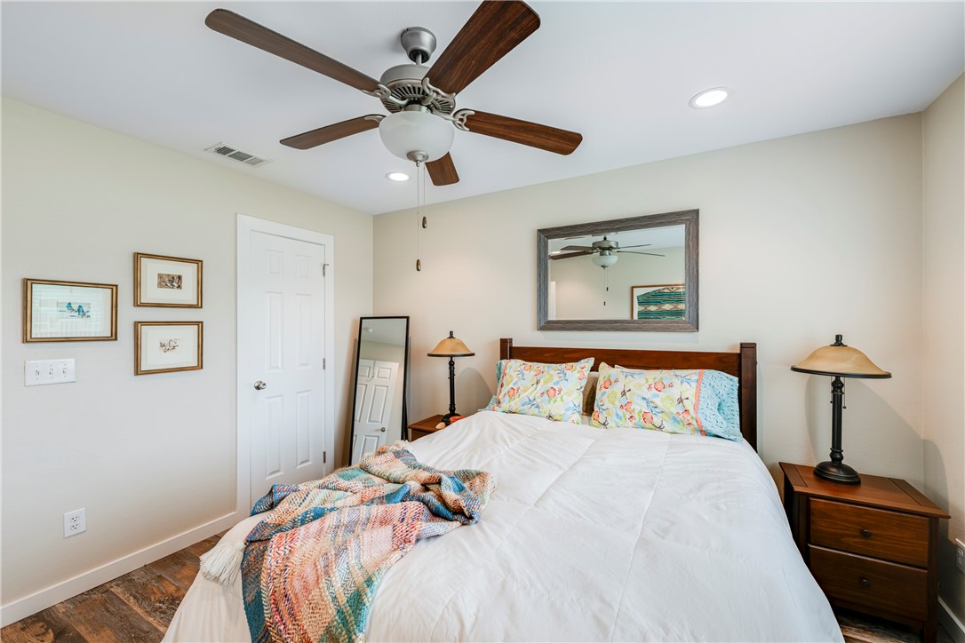 230 Cut-Off Road, Unit 101 Port Aransas, TX 78373 - Photo 13 of 30 a bedroom with a large bed and a chandelier