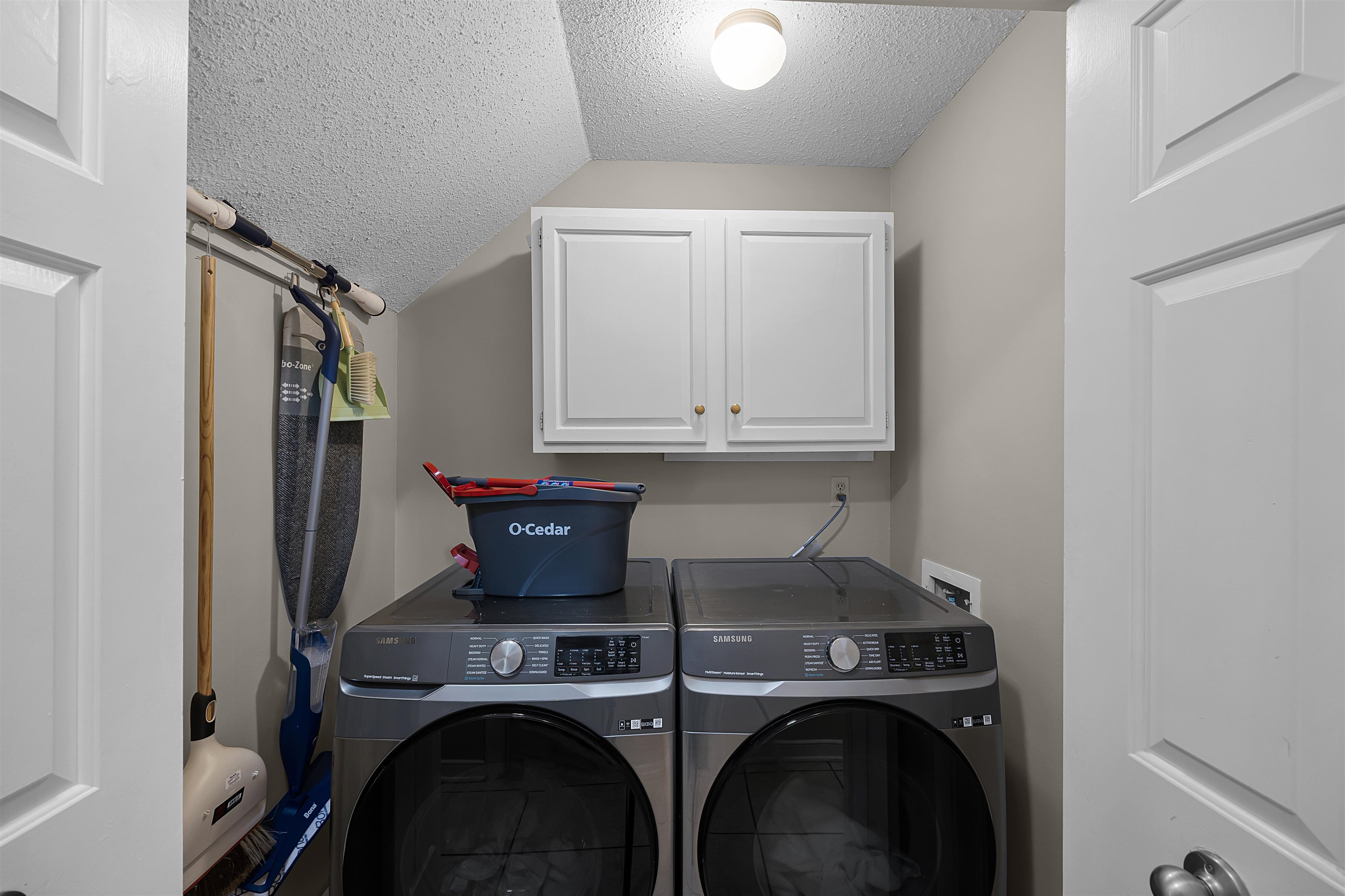 319 East Harpers Ferry Road Collierville, TN 38017 - Photo 13 of 27 Laundry area featuring washing machine and dryer, cabinets, and a textured ceiling